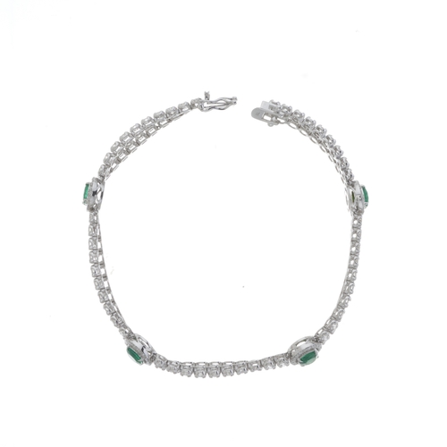 181 - An 18ct gold brilliant-cut diamond line two-row bracelet, with oval-shape emerald spacers and push-p... 