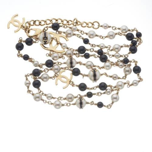 266 - Chanel, a long beaded necklace, featuring imitation pearl and black glass beads, with gold-tone CC l... 