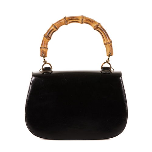 295 - Gucci, a vintage Bamboo Top Handle handbag, crafted from smooth black leather, featuring a curved ba... 