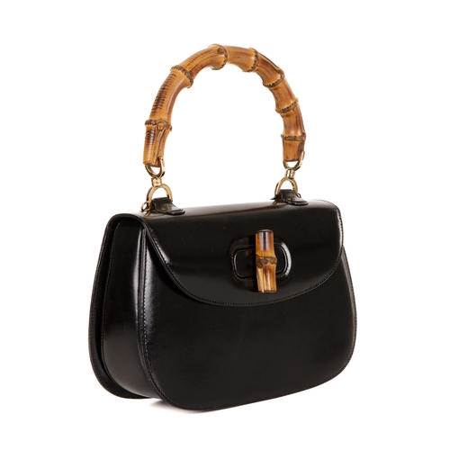 295 - Gucci, a vintage Bamboo Top Handle handbag, crafted from smooth black leather, featuring a curved ba... 