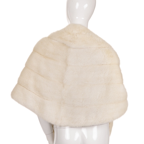 455 - A white mink fur cape/stole, featuring a lapel collar, scalloped edge details, removable mink tassel... 