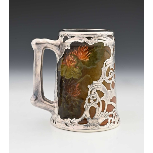 136a - A silver overlay ceramic tankard, J B Owens, in the Rookwood style with reticulated and chased tendr... 