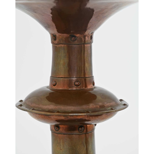 181 - Richard Llewellyn Rathbone, a pair of Arts and Crafts copper candlesticks, saucer knopped conical fo... 