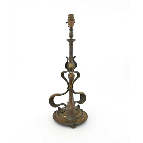 197 - An Arts and Crafts gilt brass table lamp, in the style of Jesson, Birkett and Co., the tubular uprig... 