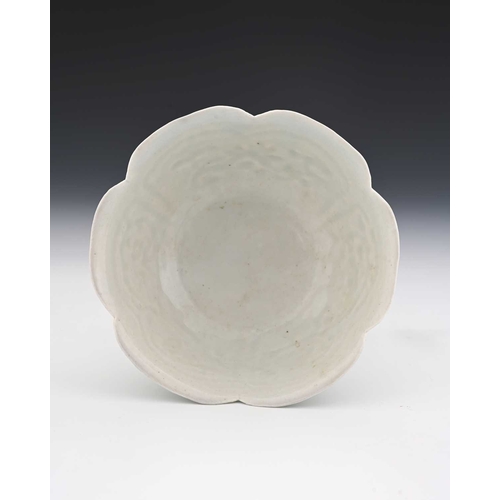 385 - A Chinese relief moulded celadon glazed pedestal bowl, petal form with beaded panels of floral and f... 