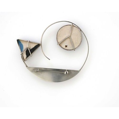 44 - A Modernist silver and ceramic brooch, London 1989, the open coiled spiral band with applied circula... 