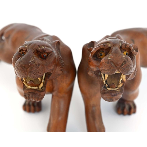 440 - A pair of Japanese carved wood figures of tigers, Meiji, modelled with bone teeth and bead eyes, pai... 