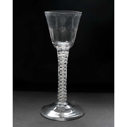 464 - An 18th century opaque twist wine or cordial glass, circa 1770, the half fluted round funnel bowl on... 