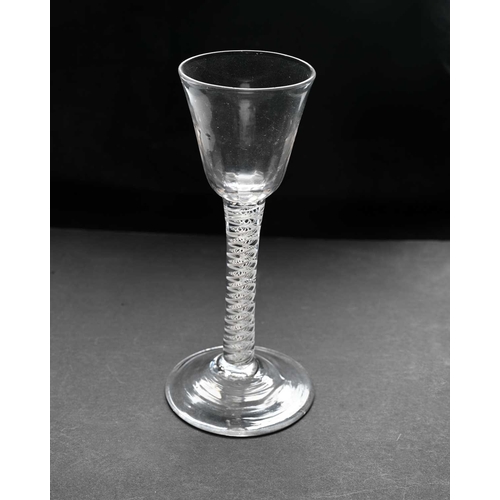 464 - An 18th century opaque twist wine or cordial glass, circa 1770, the half fluted round funnel bowl on... 