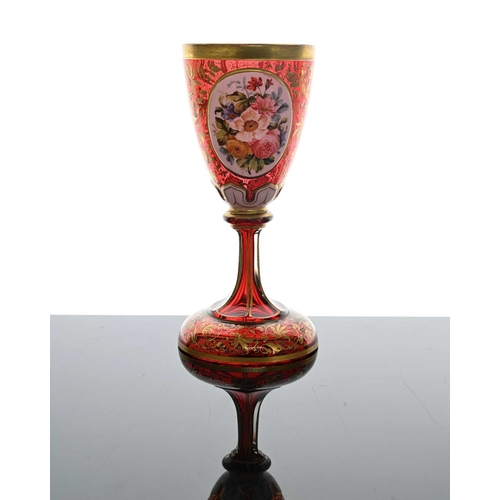 484 - A Bohemian floral plaque red glass goblet vase, 19th century, pedestal chalice form, two opaque oval... 