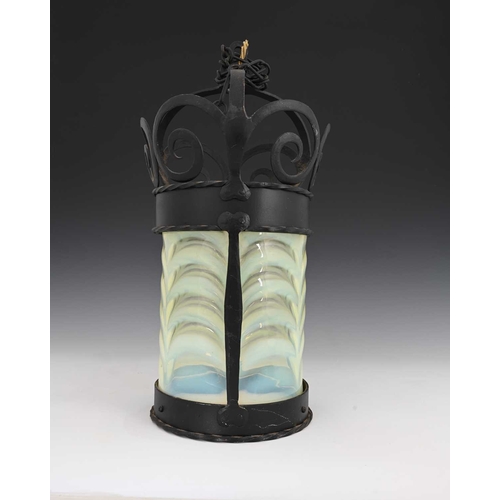 503 - An Arts and Crafts straw opal glass and wrought iron lantern pendant, the cylindrical shade in the s... 