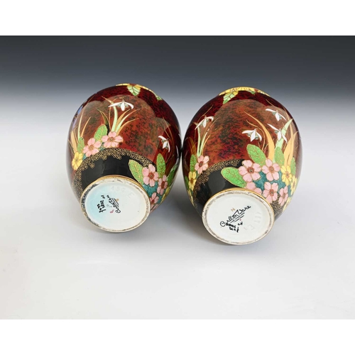 563 - A pair of Carlton Ware Bluebells Rouge Royale vases, shouldered form, decorated with enamelled flowe... 