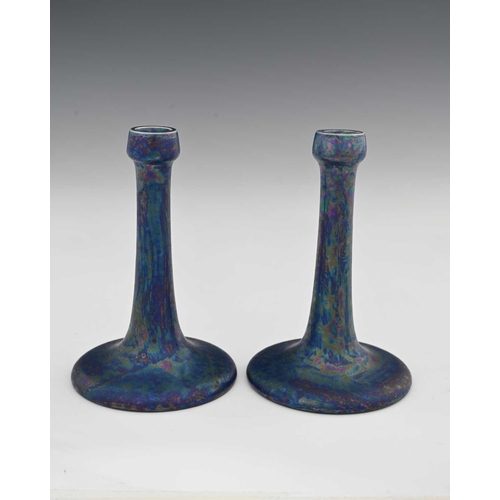 600 - Ruskin Pottery, a pair of Kingfisher blue lustre candlesticks, 1917, tapered trumpet form with poppy... 