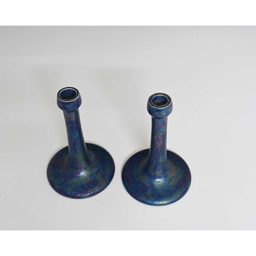 600 - Ruskin Pottery, a pair of Kingfisher blue lustre candlesticks, 1917, tapered trumpet form with poppy... 