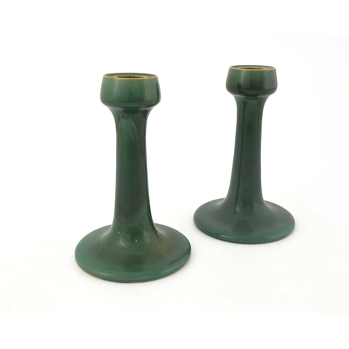 618 - Ruskin Pottery, a pair of Souffle glazed candlesticks, circa 1903, trumpet form with poppy head scon... 