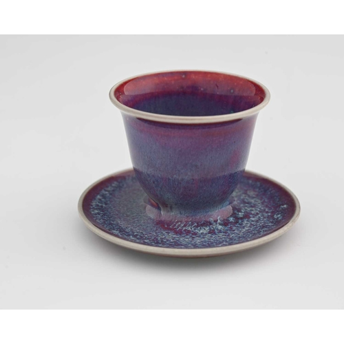 624 - Ruskin Pottery, a High Fired egg cup, 1925, the ogee form bowl with integrated dish, lavender and re... 