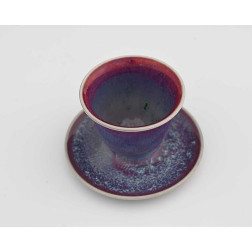 624 - Ruskin Pottery, a High Fired egg cup, 1925, the ogee form bowl with integrated dish, lavender and re... 