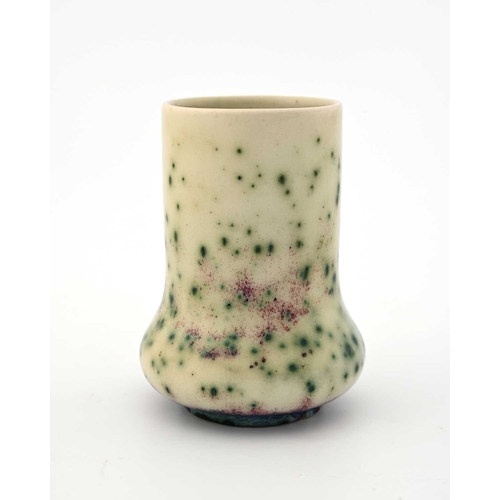 626 - Ruskin Pottery, a small High Fired vase, circa 1925, elephant foot form, white with green oxide spec... 