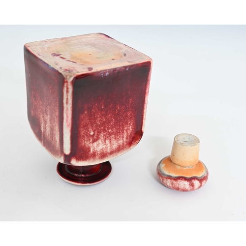 629 - Ruskin Pottery, a High Fired scent bottle, circa 1920s, cuboid form with bun stopper, red sang de bo... 