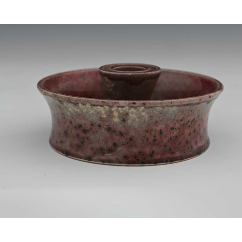 636 - Ruskin Pottery, a High Fired candle holder, 1931, flared circular dish form with central conical sco... 