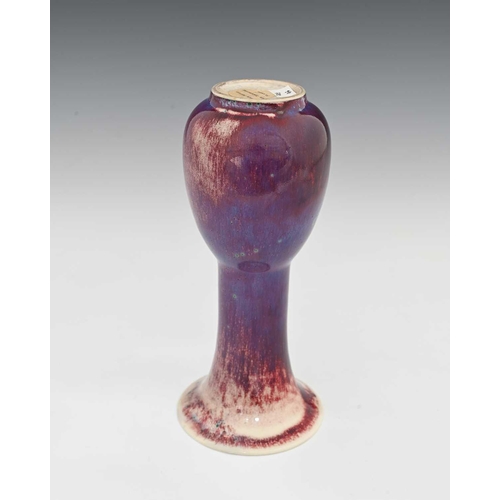 637 - Ruskin Pottery, a High Fired vase, 1925, elongated bulbous bottle form with flared trumpet neck, pur... 