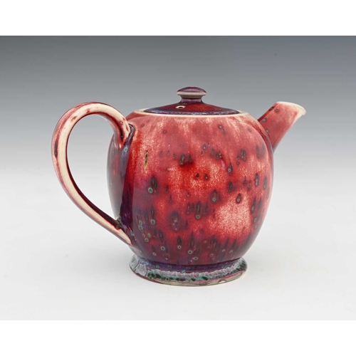 640 - Ruskin Pottery, a High Fired teapot, 1926, footed ovoid form, red sang de boeuf flambe draining to p... 