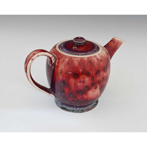 640 - Ruskin Pottery, a High Fired teapot, 1926, footed ovoid form, red sang de boeuf flambe draining to p... 