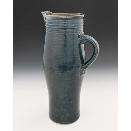 668 - Michael Casson, a studio pottery jug, slender elongated barrel form, blue glazed with fluted banding... 