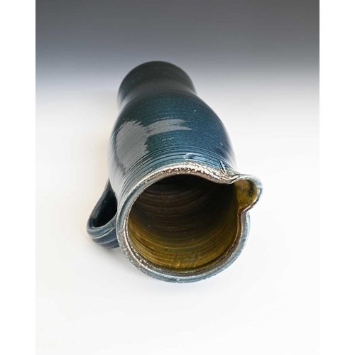 668 - Michael Casson, a studio pottery jug, slender elongated barrel form, blue glazed with fluted banding... 