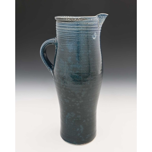 668 - Michael Casson, a studio pottery jug, slender elongated barrel form, blue glazed with fluted banding... 