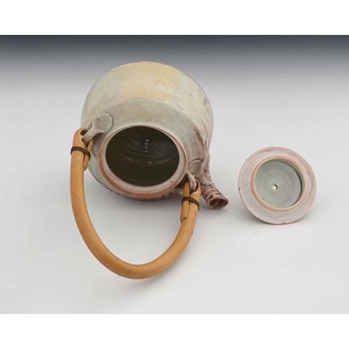 689 - Mary Rich (British, 1940-2022), a stoneware cane-handled teapot and cover, decorated with a pale whi... 