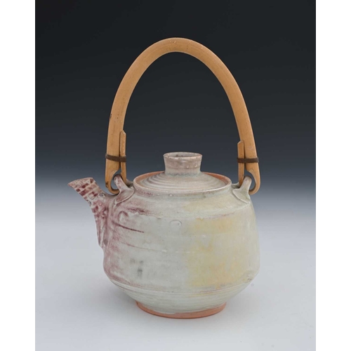 689 - Mary Rich (British, 1940-2022), a stoneware cane-handled teapot and cover, decorated with a pale whi... 