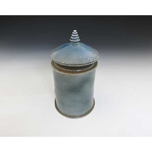 710 - Walter Keeler, a studio pottery salt glazed jar and cover, oval section pale blue glaze, circular co... 