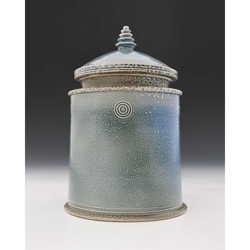 710 - Walter Keeler, a studio pottery salt glazed jar and cover, oval section pale blue glaze, circular co... 