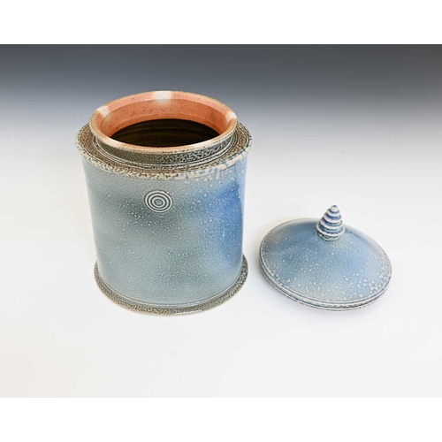 710 - Walter Keeler, a studio pottery salt glazed jar and cover, oval section pale blue glaze, circular co... 