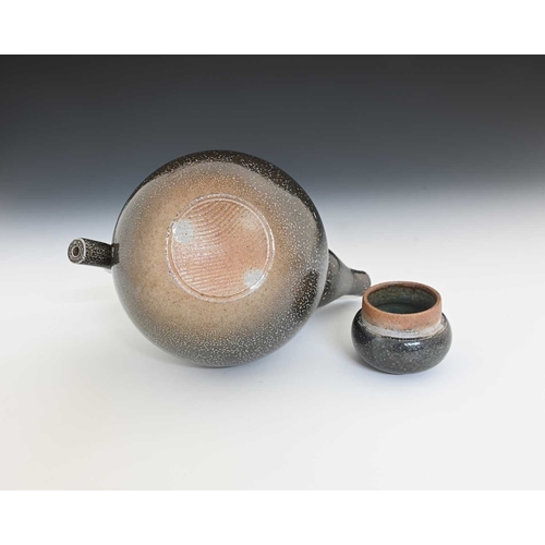 712 - Walter Keeler, a studio pottery salt glazed stoneware teapot, the spherical body with baluster cone ... 