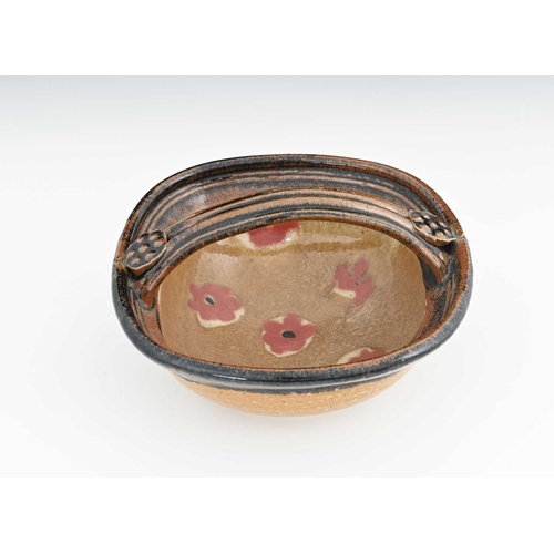 719 - John Maltby (British, 1936-2020), a strap-handled dish, decorated inside with a soft red floral moti... 