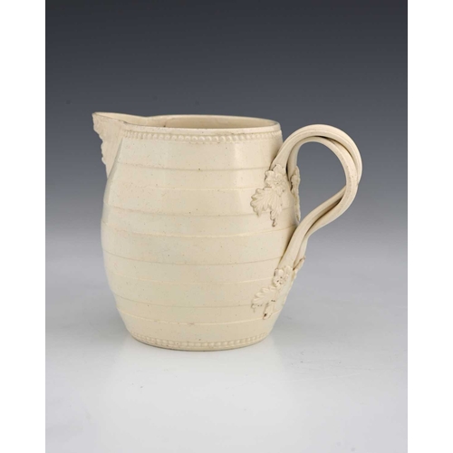 727 - A Leeds creamware mask head milk jug, circa 1780, of barrel form, turned banding with crossover foli... 