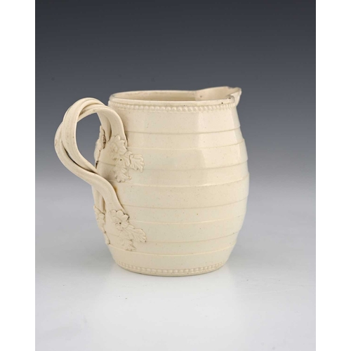 727 - A Leeds creamware mask head milk jug, circa 1780, of barrel form, turned banding with crossover foli... 