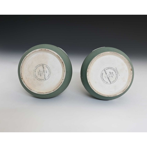 729 - Wedgwood for Humphrey Taylor & Co, London, a pair of buff green jasper dip liqueur bottles and stopp... 