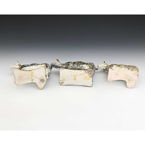 745 - Three 19th century Prattware sponge decorated pottery cow creamers, modelled on platform bases, two ... 