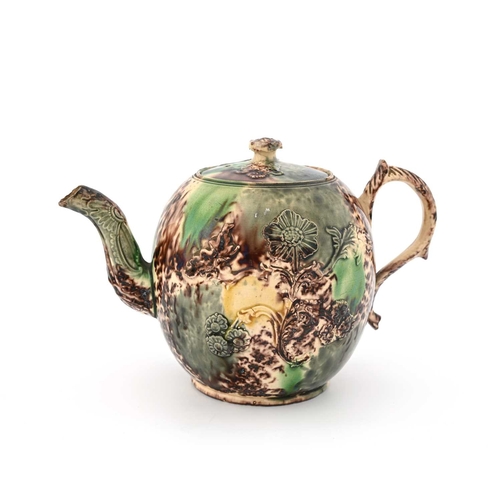 749 - A Whieldon sprigged teapot, circa 1740, spherical form with Rococo foliate handle, applied with reli... 