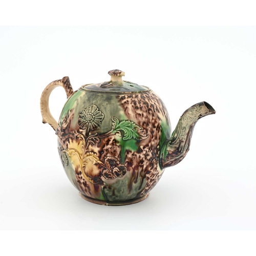 749 - A Whieldon sprigged teapot, circa 1740, spherical form with Rococo foliate handle, applied with reli... 