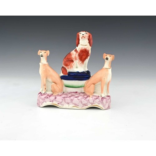 766 - A Staffordshire pottery figure group of three dogs, circa 1850, on a marble effect integrated base,