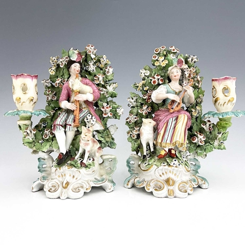 768 - A pair of Derby porcelain shepherd and shepherdess figural candlesticks, circa 1770, bocage backed, ... 