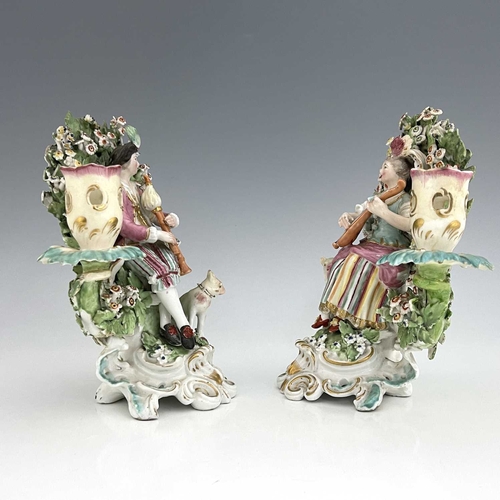 768 - A pair of Derby porcelain shepherd and shepherdess figural candlesticks, circa 1770, bocage backed, ... 