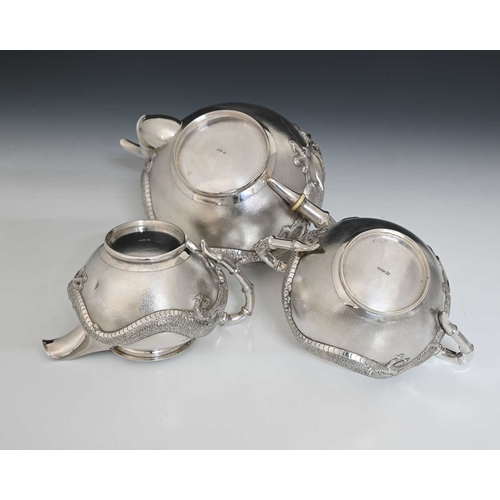 102 - China. An early twentieth-century Chinese export silver three-piece tea set, comprising teapot, two-... 