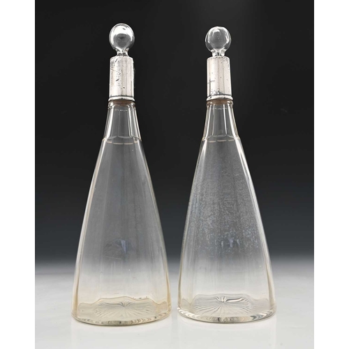 109 - A pair of George V silver-mounted glass decanters, each of optic ribbed tapered form, with spherical... 