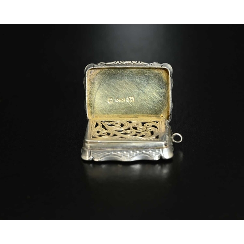 11 - A Victorian silver vinaigrette, of shaped rectangular form, the exterior decorated with engine turni... 