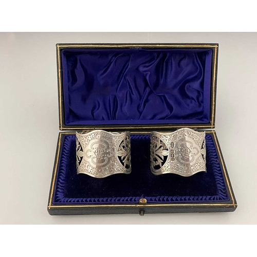 126 - A cased pair of Edwardian silver napkin rings, each of cylindrical form with wavy-edge rim, the body... 